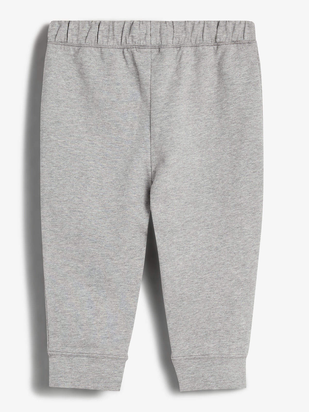 Gray sweatpants with an elastic waistband lay flat against a plain white background, showcasing their simple design and comfortable fabric in a well-lit environment.