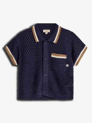 A navy blue knitted short-sleeve shirt with button closure is presented on a plain background. It features a textured pattern, pocket with beige accents, and a label reading "puma kids."