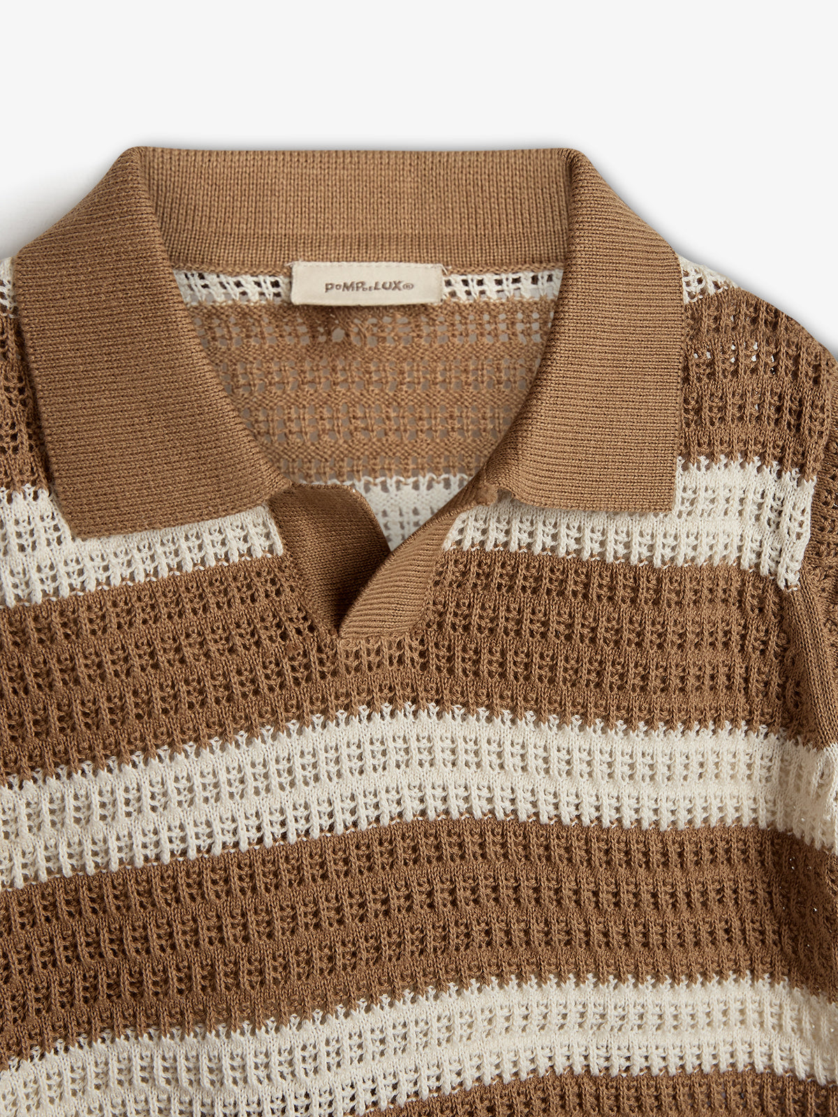 A crocheted short-sleeve shirt displays brown and white horizontal stripes, featuring a brown collar with a V-neck opening. A label inside the collar reads “p o m p d e L U X ©”.