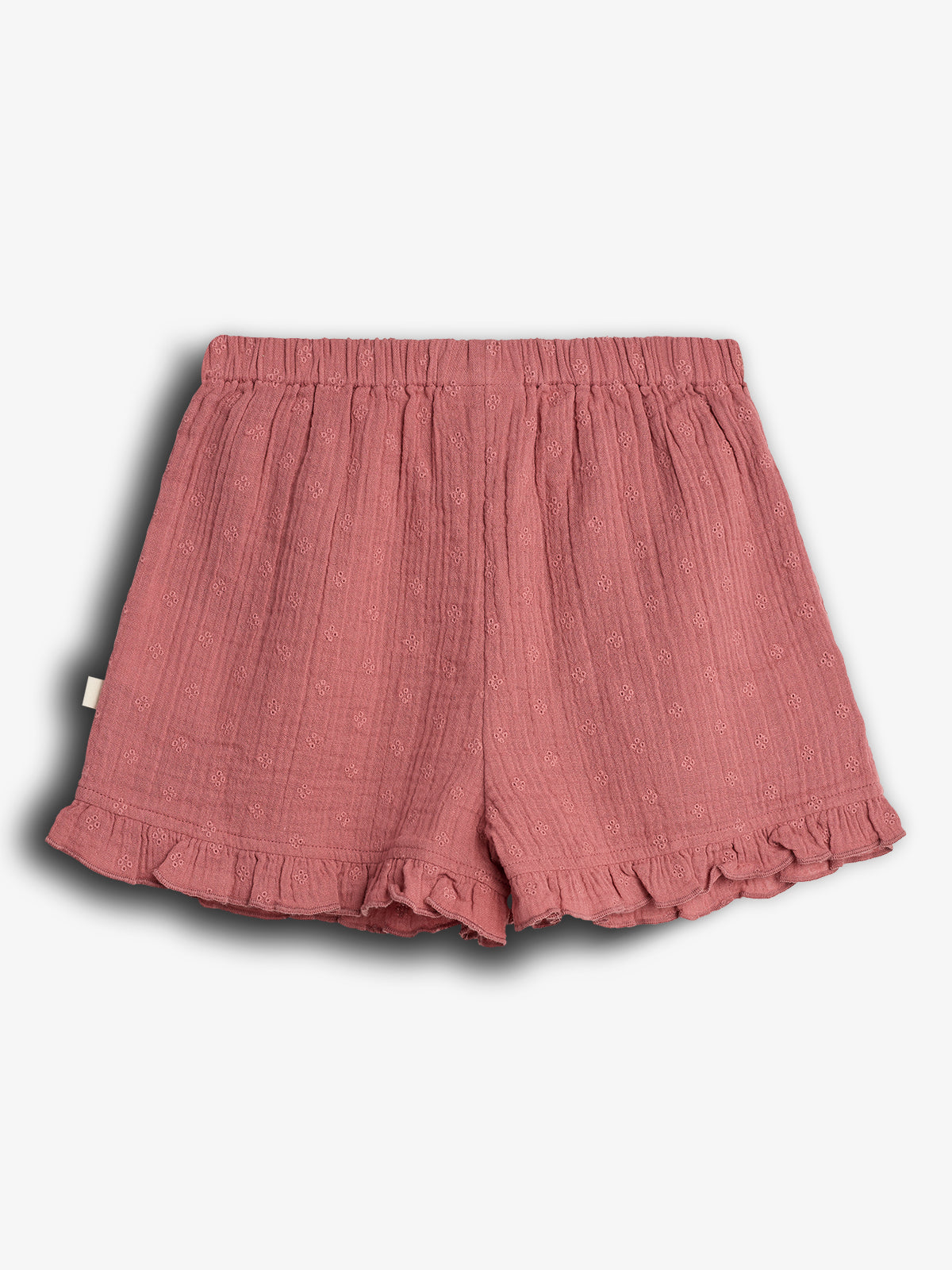 Pink shorts with an elastic waistband feature small embroidered flowers and ruffled hems. They are displayed on a plain white background, emphasizing their textured fabric and design.