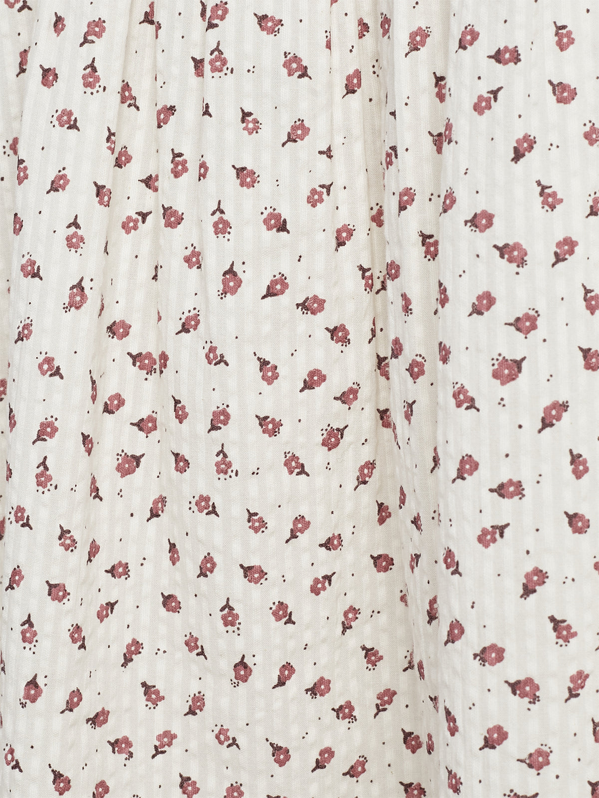 Fabric displays a pattern of small, pink floral designs scattered uniformly. The light background enhances the visibility of the delicate flowers, creating a subtle and vintage aesthetic.