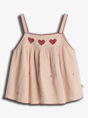 A light pink sleeveless top with red heart embroidery across the chest. It has thin straps and small scattered heart patterns, complementing a delicate, textured fabric.