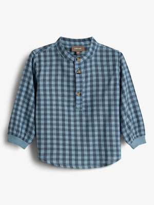 A blue plaid long-sleeved shirt with a mandarin collar and three brown buttons is displayed against a plain white background. Label text reads: "POMP de LUX, 86."