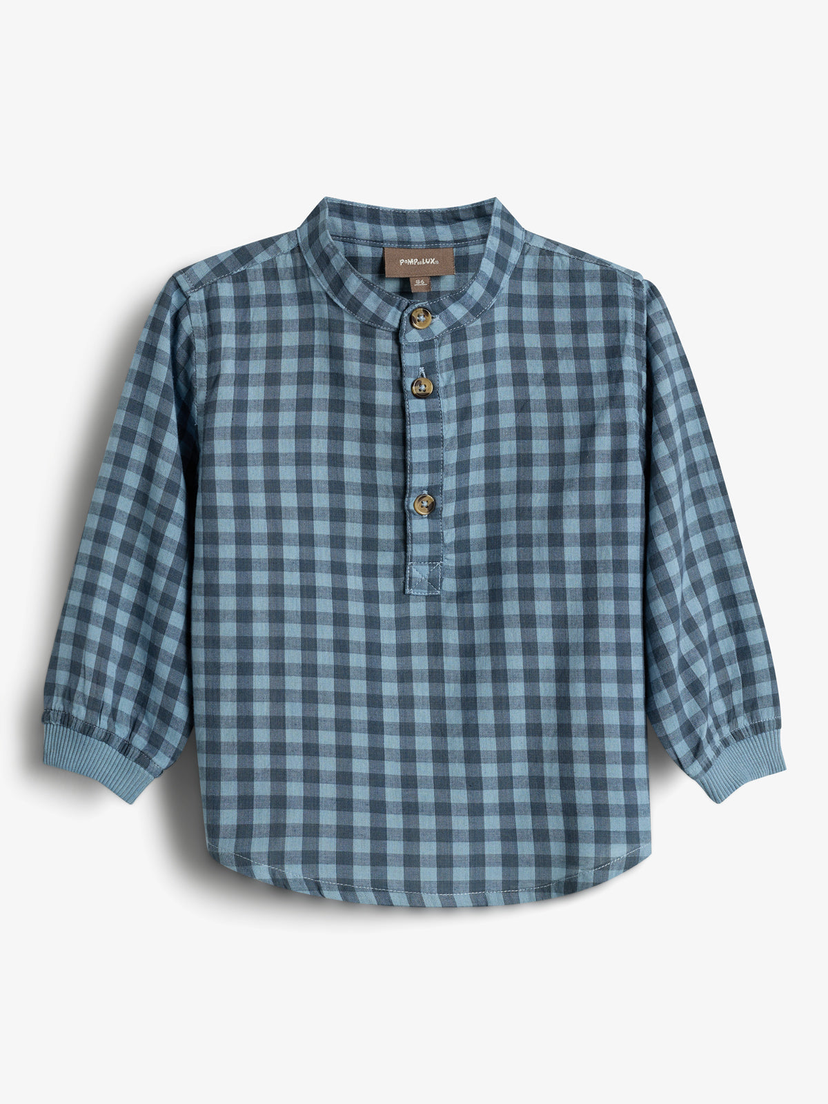 A blue plaid long-sleeved shirt with a mandarin collar and three brown buttons is displayed against a plain white background. Label text reads: "POMP de LUX, 86."