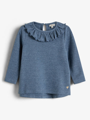 A blue long-sleeve toddler shirt with a ruffled collar hangs against a plain background. It features a small gold heart detail at the bottom.