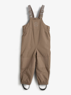 Tan overalls with adjustable shoulder straps, featuring elasticized cuffs and foot loops. Text on straps reads "HUMPDLUX ADVENTURE." Context is a plain white background.