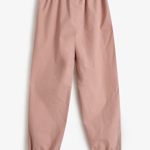 Pink elastic-waist pants lie flat on a white background, featuring gathered cuffs. Printed text on the right leg reads "polder day rainwear," adding a functional design element.