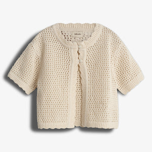 A cream-colored, short-sleeved crochet cardigan featuring a buttoned front detail is laid flat against a plain, light background. A label inside reads: "maha Lulo".